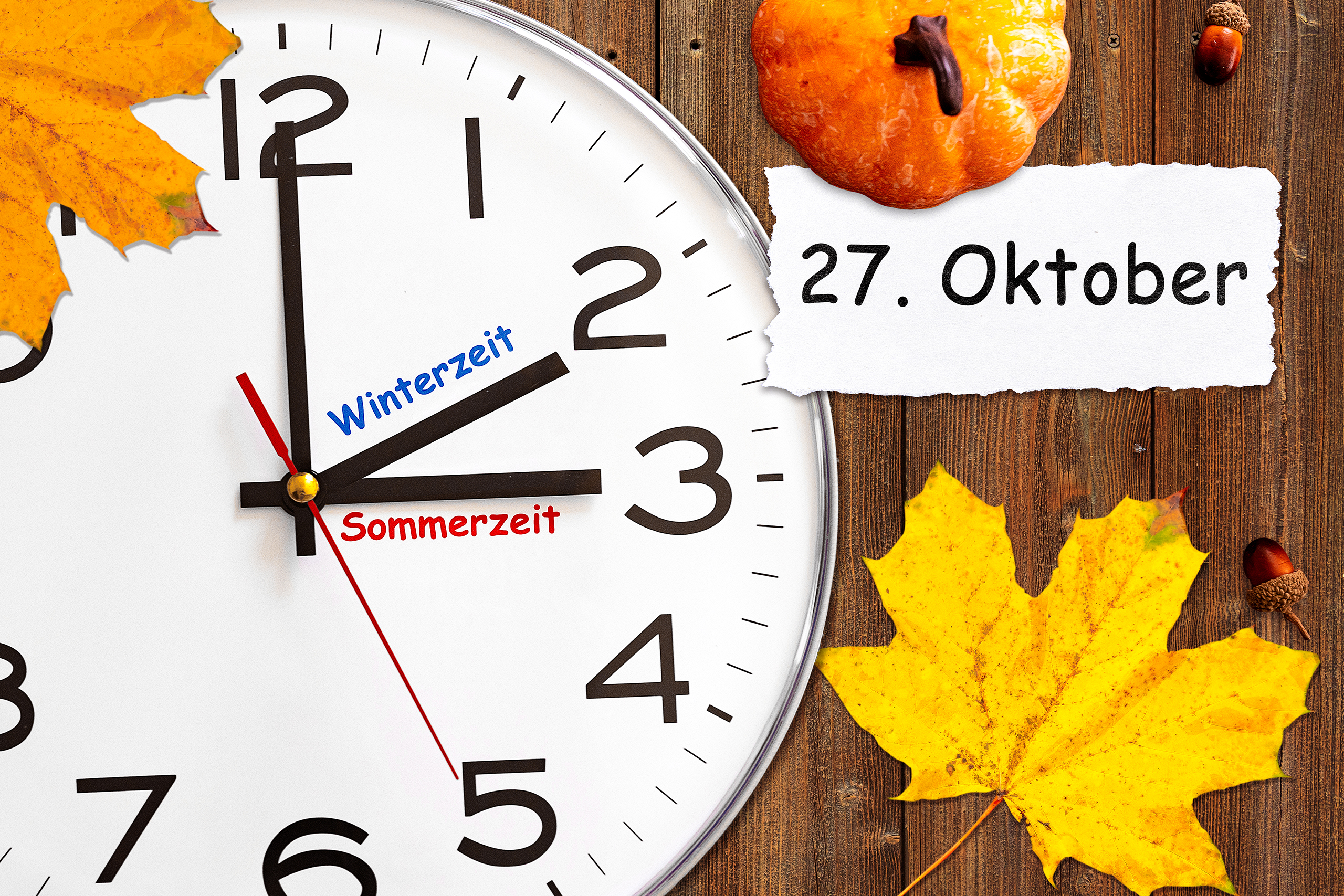 zeitumstellung 2024 auf winterzeit mit uhr, herbstblättern und dem datum 27. oktober.