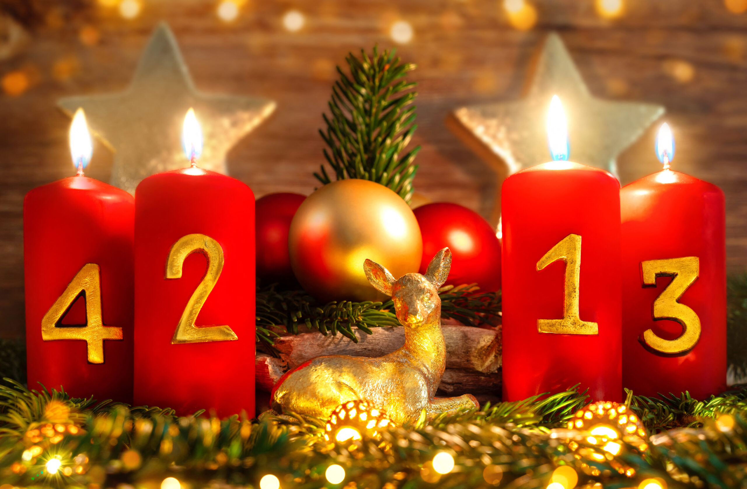 vier rote adventskerzen mit goldenen zahlen und weihnachtsdekoration zum 4. advent