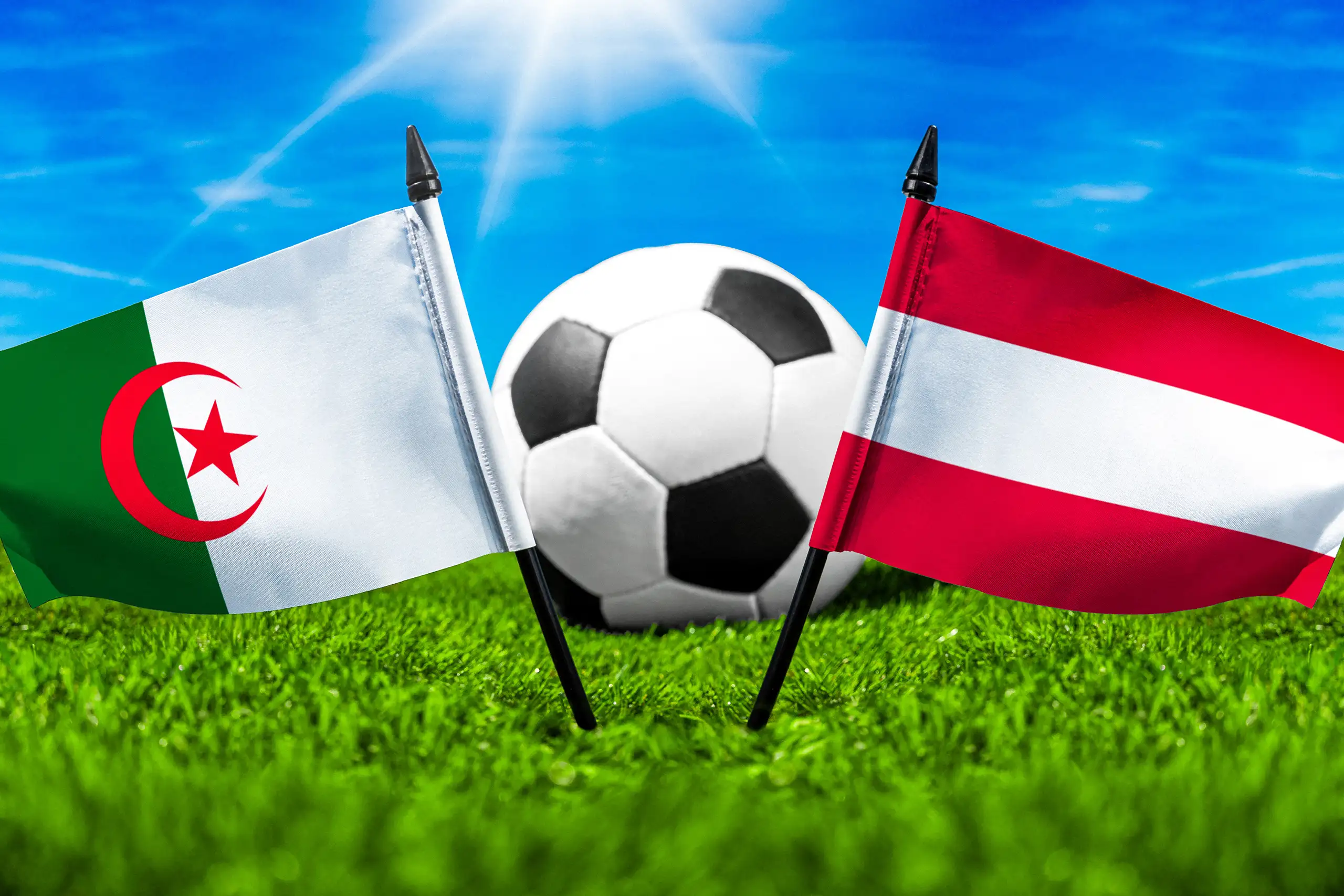 nationalflaggen von algerien und österreich vor einem fußball auf grünem rasen unter blauem himmel.