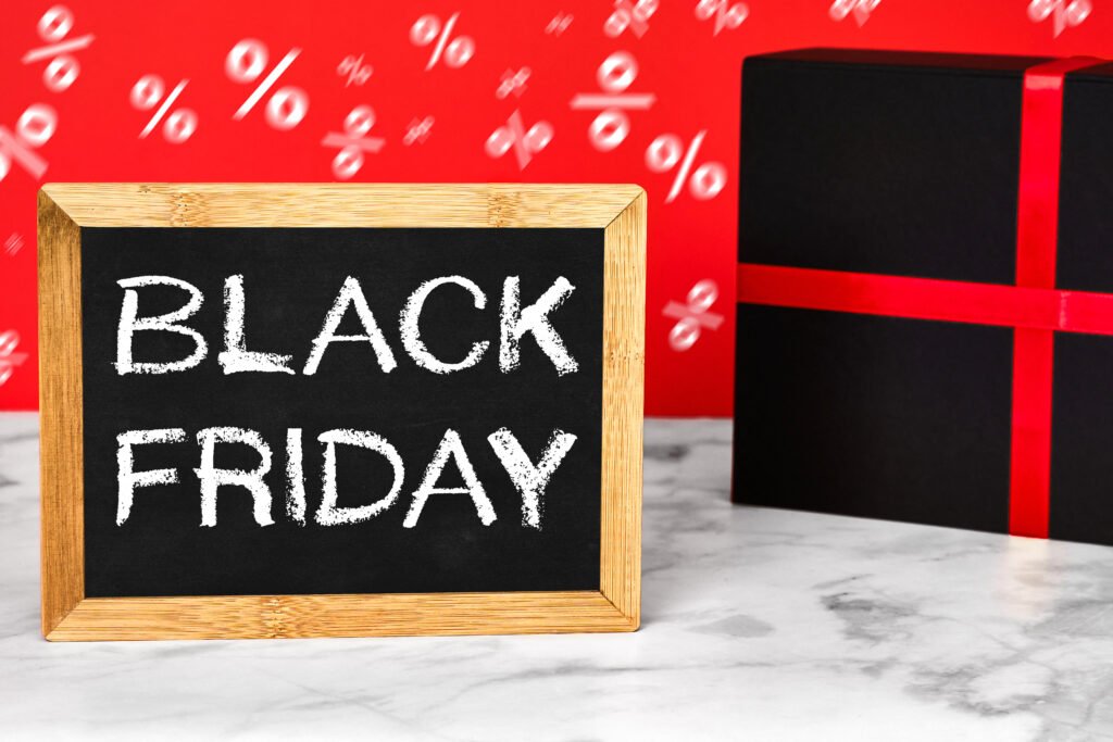 Black Friday – Kreidetafel mit Schriftzug BLACK FRIDAY und Geschenkbox mit rotem Band