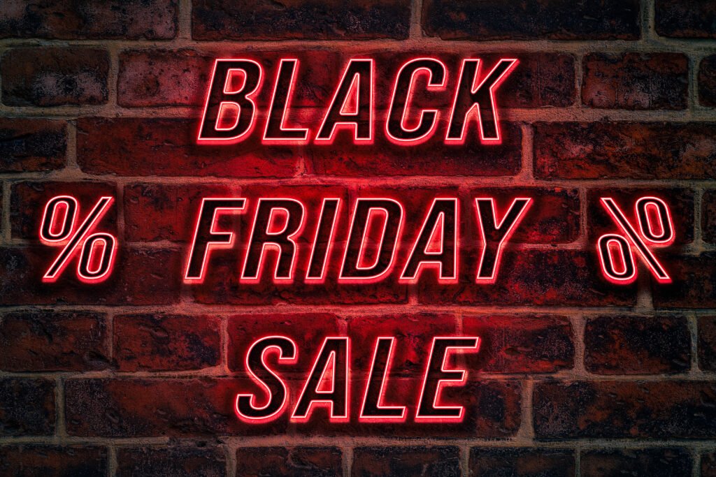 Black Friday Schriftzug – leuchtender Text BLACK FRIDAY SALE in roten Neonbuchstaben auf Backsteinwand