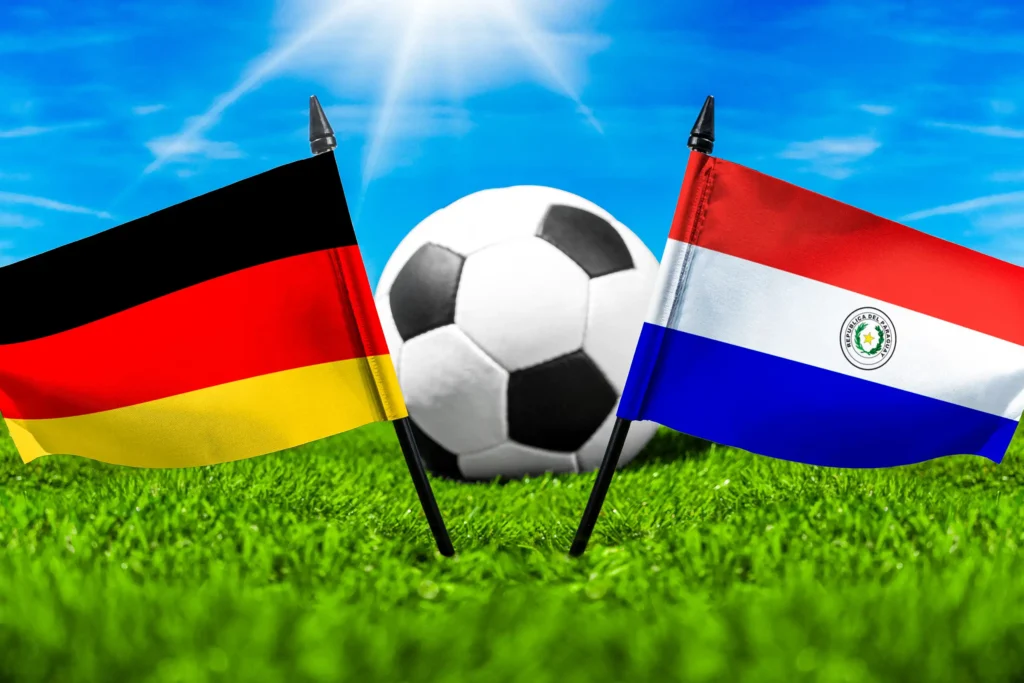 Nationalflaggen von Deutschland und Paraguay mit Fußball auf grünem Rasen als Motiv für ein internationales Fußballspiel.