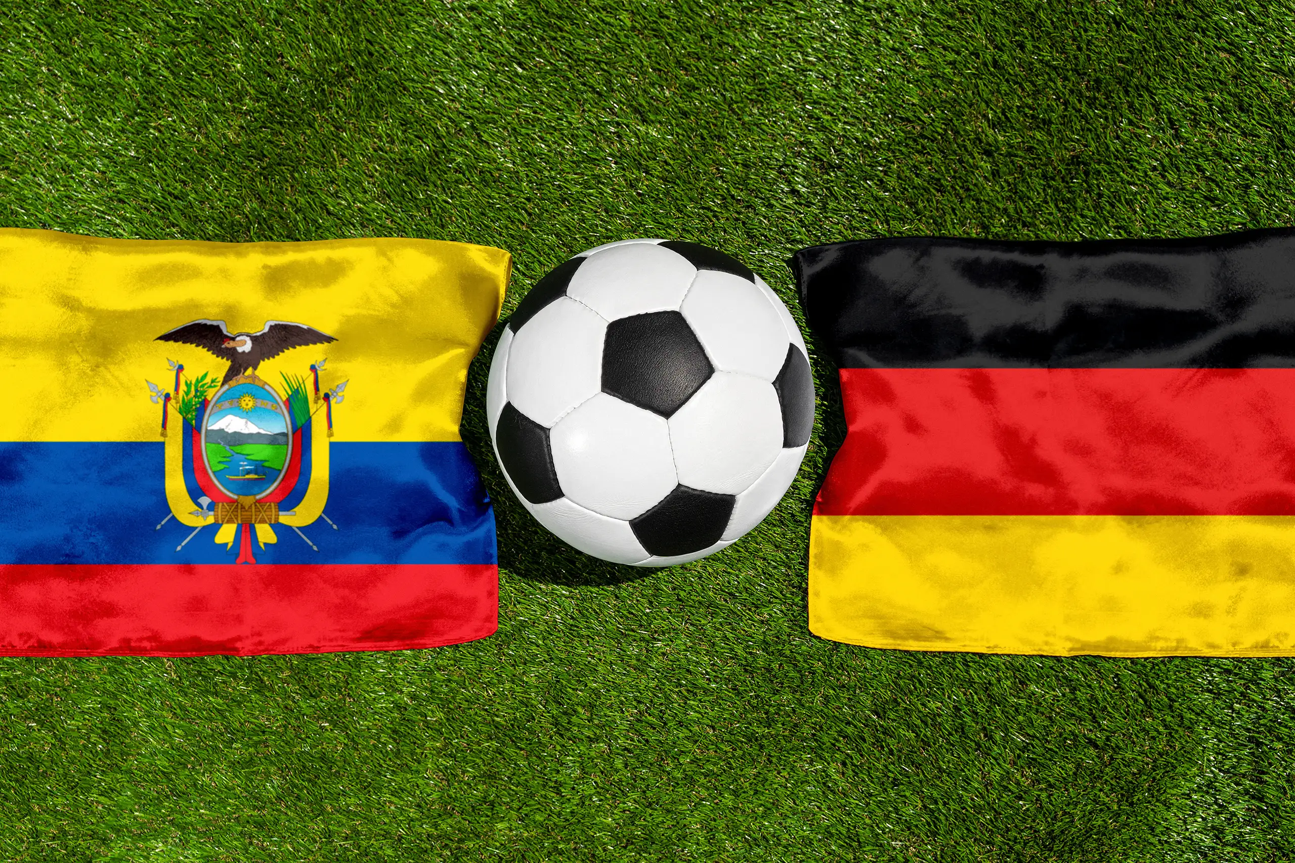ecuador gegen deutschland fußball mit ball und nationalflaggen auf dem spielfeld.