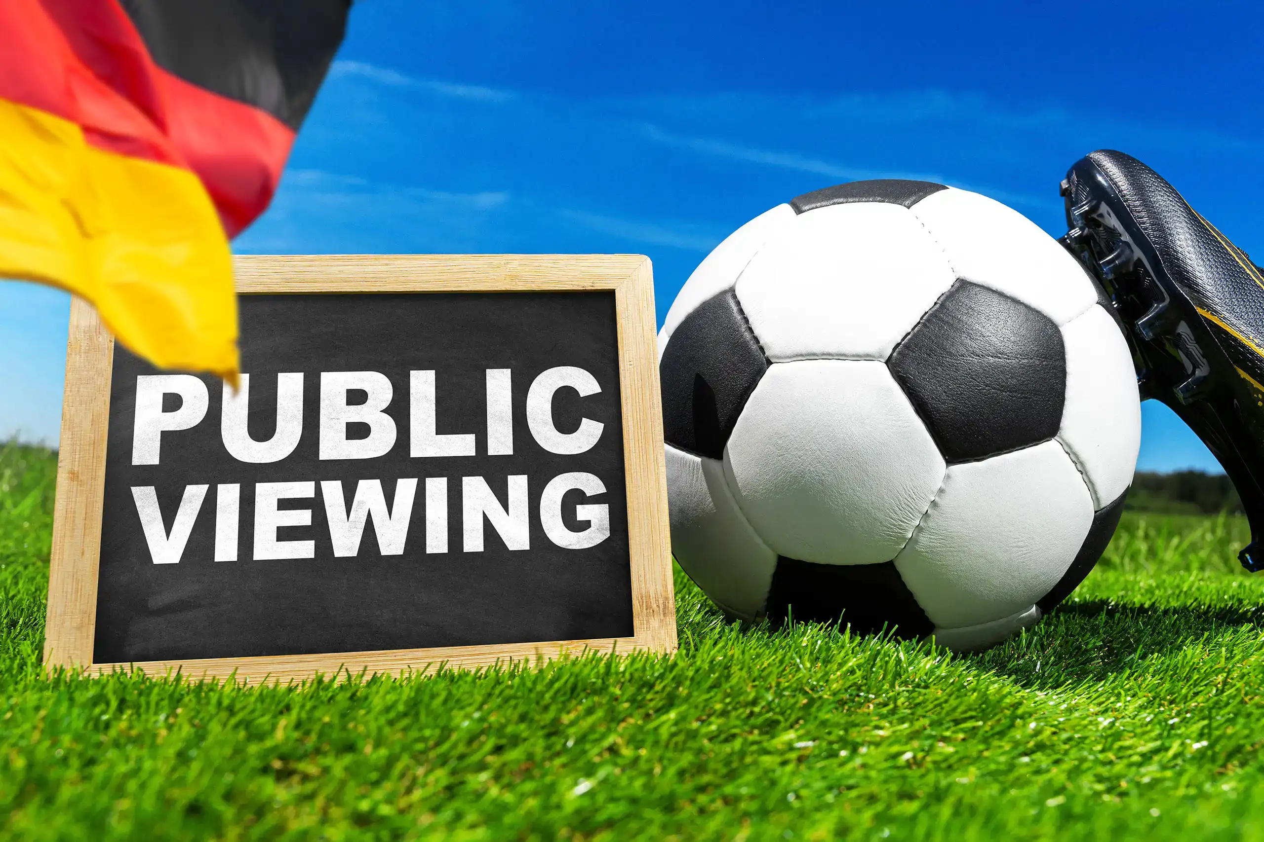public viewing deutschland fußball mit fußball, deutschland fahne und fußballschuh auf grünem rasen.