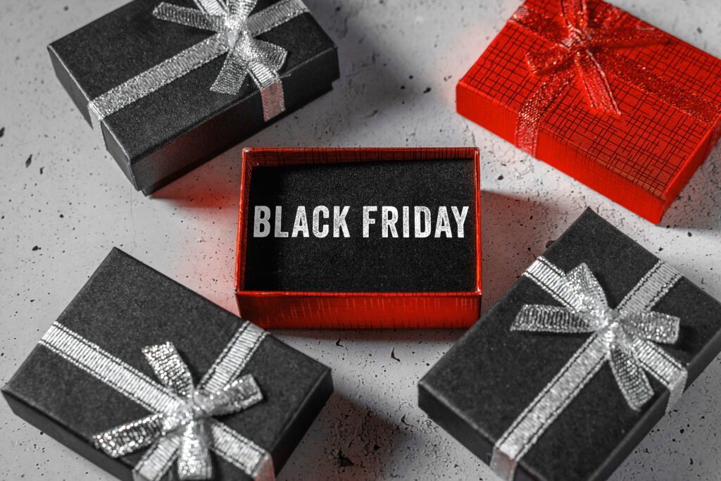 Geschenk zu Black Friday – rote Box mit Schriftzug BLACK FRIDAY, umgeben von schwarzen Geschenken mit silbernen Schleifen