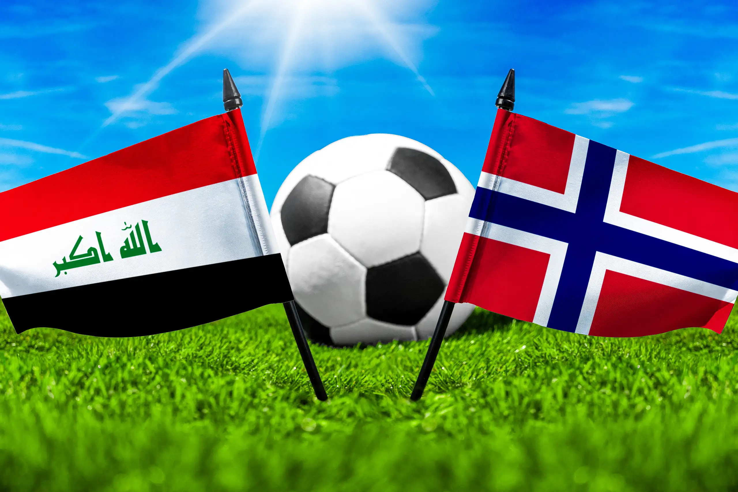 nationalflaggen von irak und norwegen vor einem fußball auf grünem rasen unter blauem himmel.
