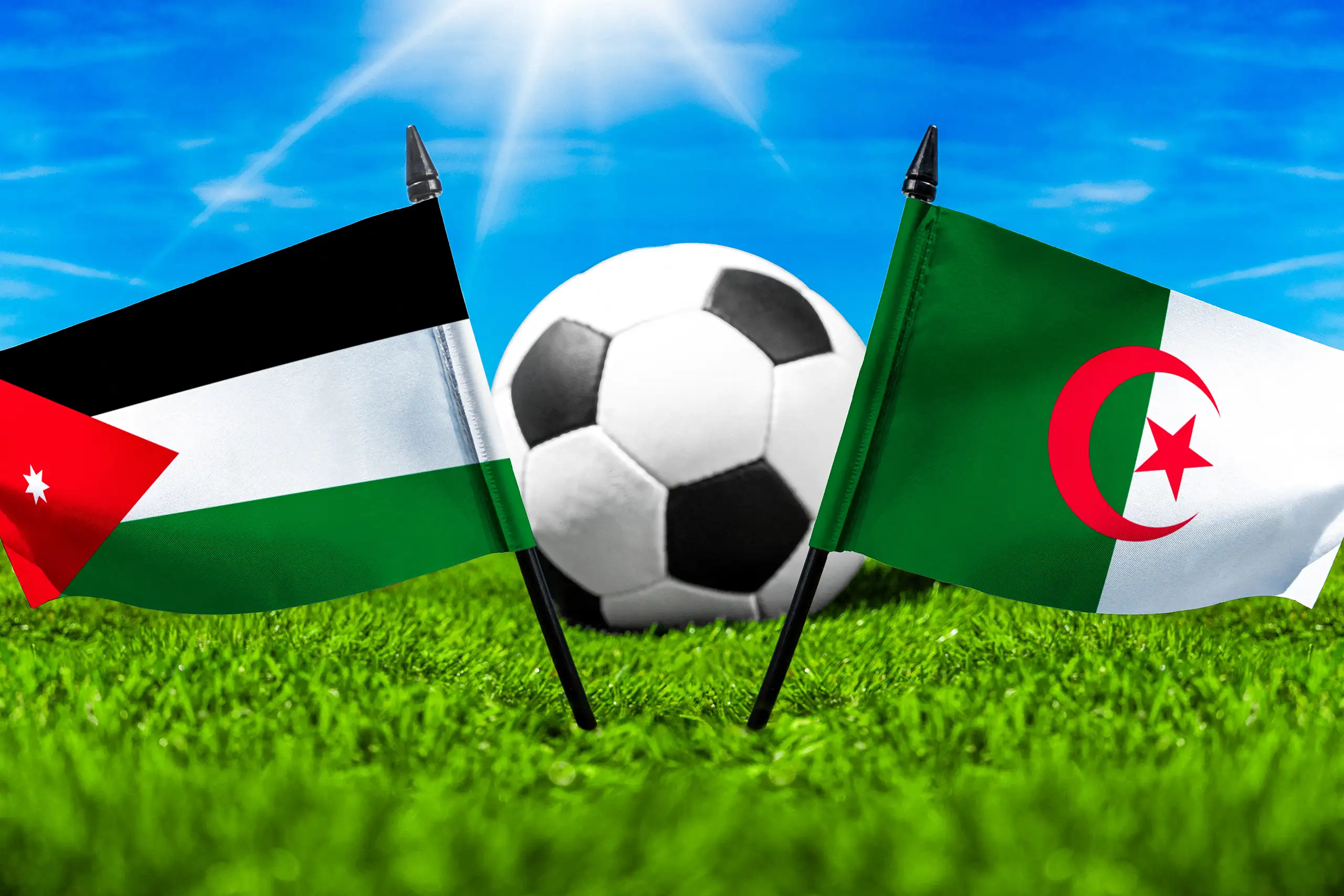 jordanien gegen algerien mit fußball auf rasen und den nationalflaggen beider länder unter blauem himmel.