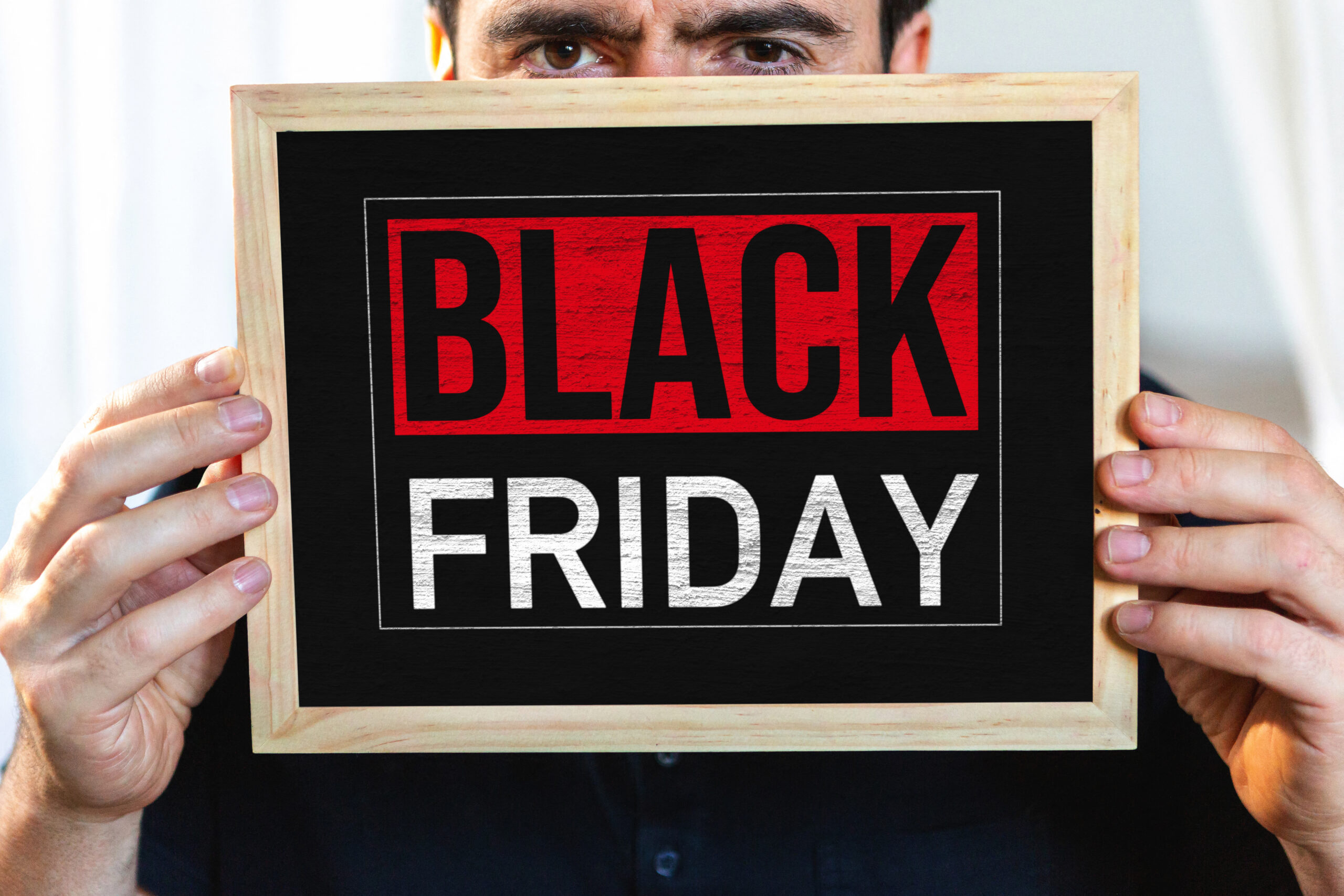BLACK FRIDAY BILDER MANN MIT BLACK FRIDAY SCHILD – PERSON HÄLT SCHILD MIT SCHRIFTZUG BLACK FRIDAY IN ROT-SCHWARZ-DESIGN mann mit black friday schild – person hält schild mit schriftzug black friday in rot-schwarz-design