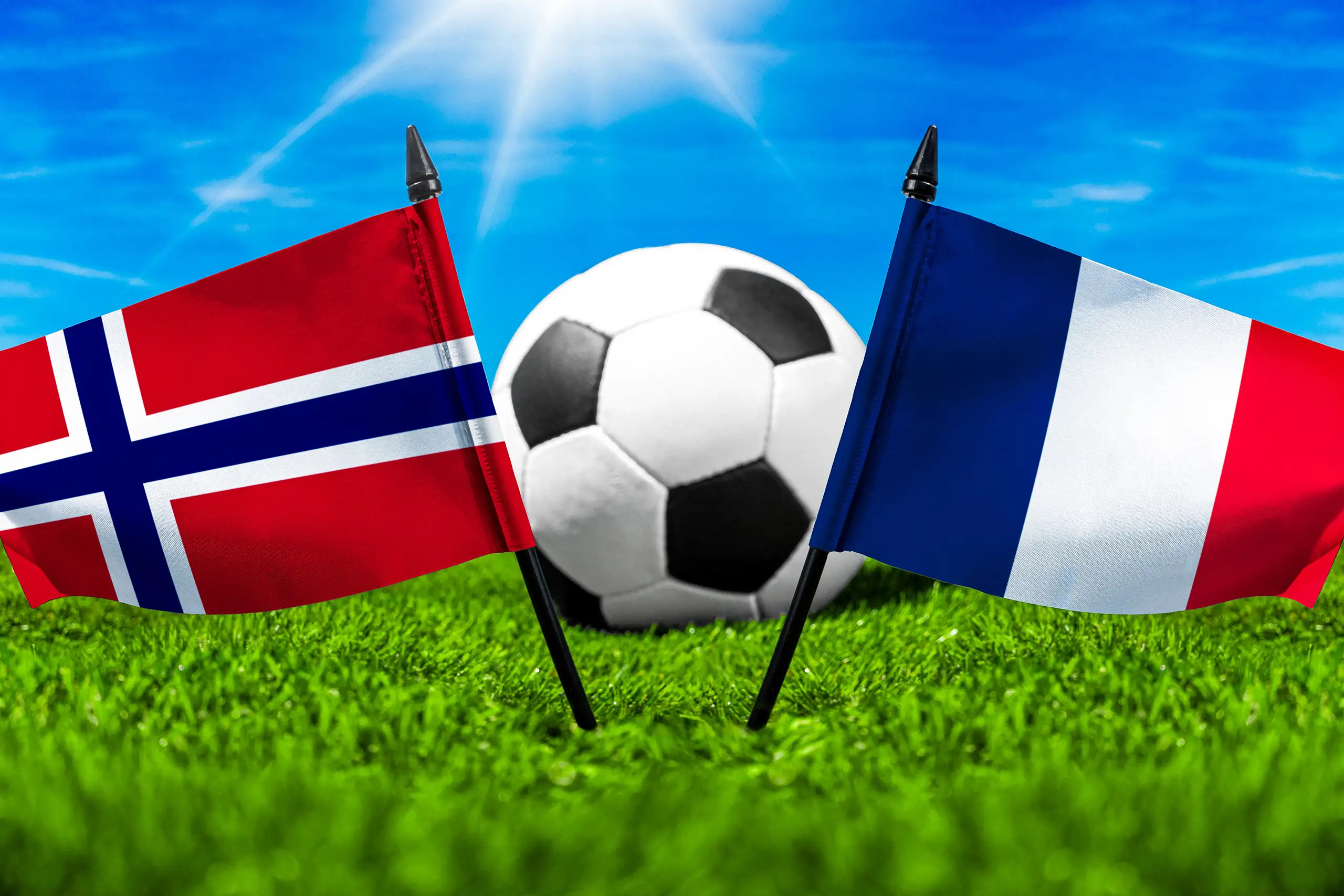 nationalflaggen von norwegen und frankreich vor einem fußball auf grünem rasen unter blauem himmel.