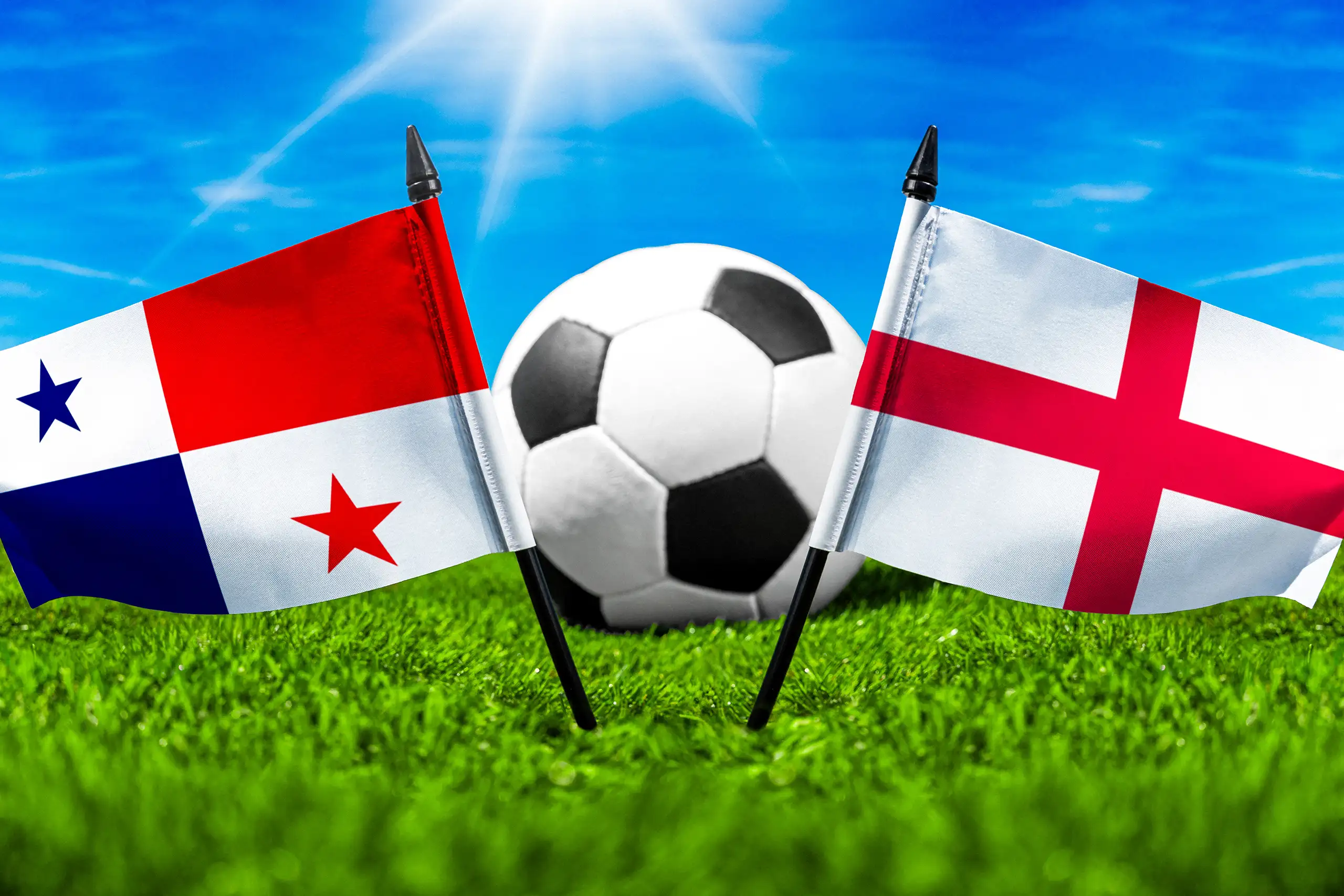 panamaische und englische nationalflagge neben einem fußball auf rasen mit blauem himmel im hintergrund.