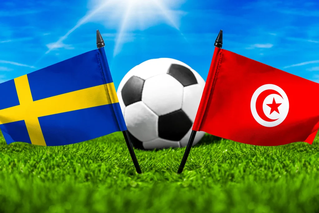Schweden Tunesien Fußballspiel mit Fußball zwischen den Nationalflaggen von Schweden und Tunesien auf grünem Spielfeld.