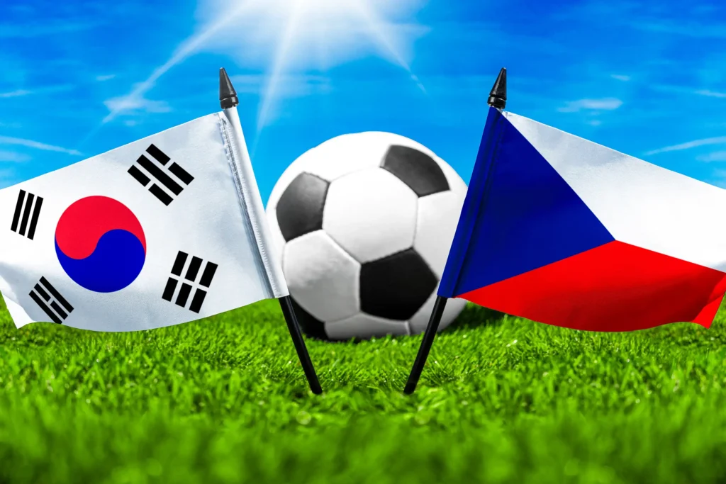 Südkorea Tschechien Fußballspiel mit Fußball zwischen den Nationalflaggen von Südkorea und Tschechien auf grünem Rasen.