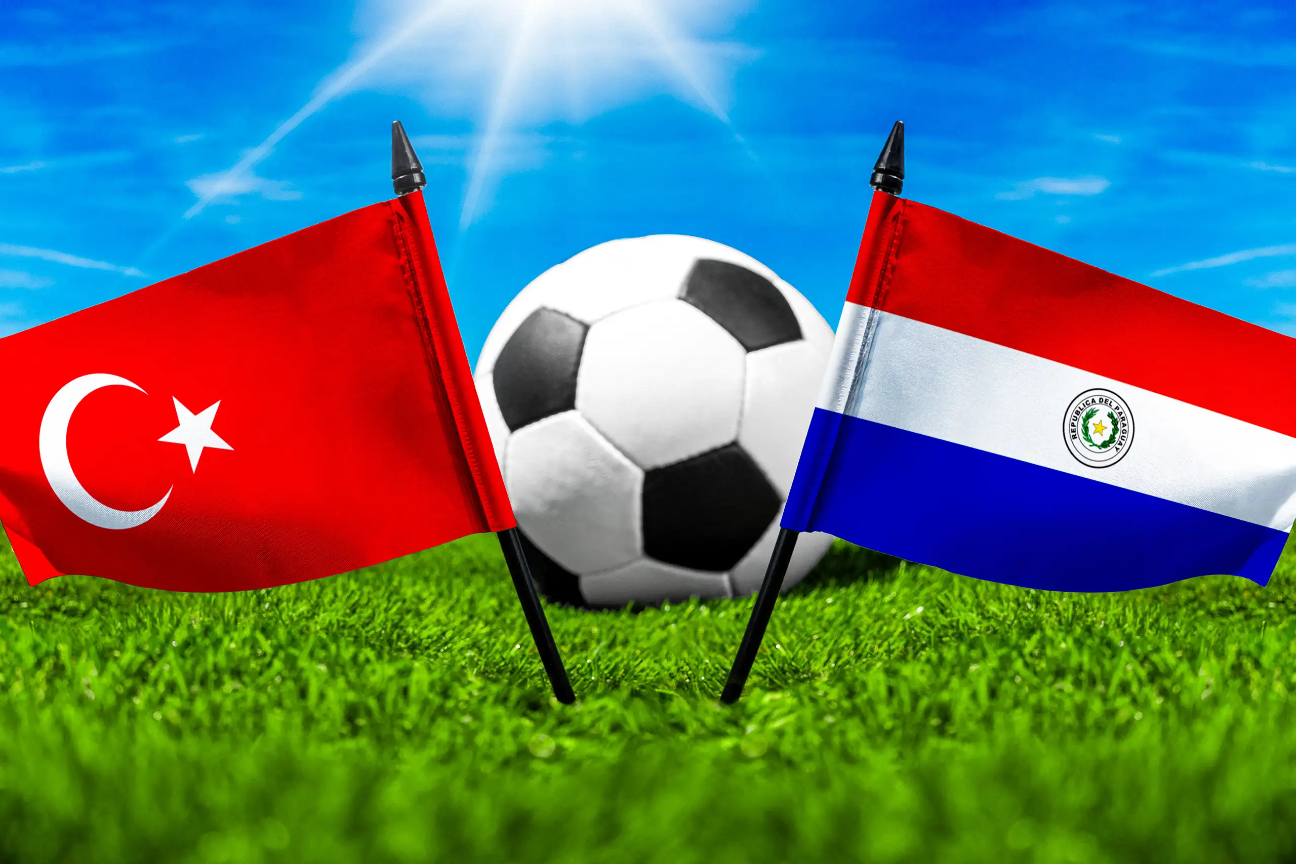 flaggen der türkei und paraguays mit fußball auf grünem rasen unter blauem himmel.