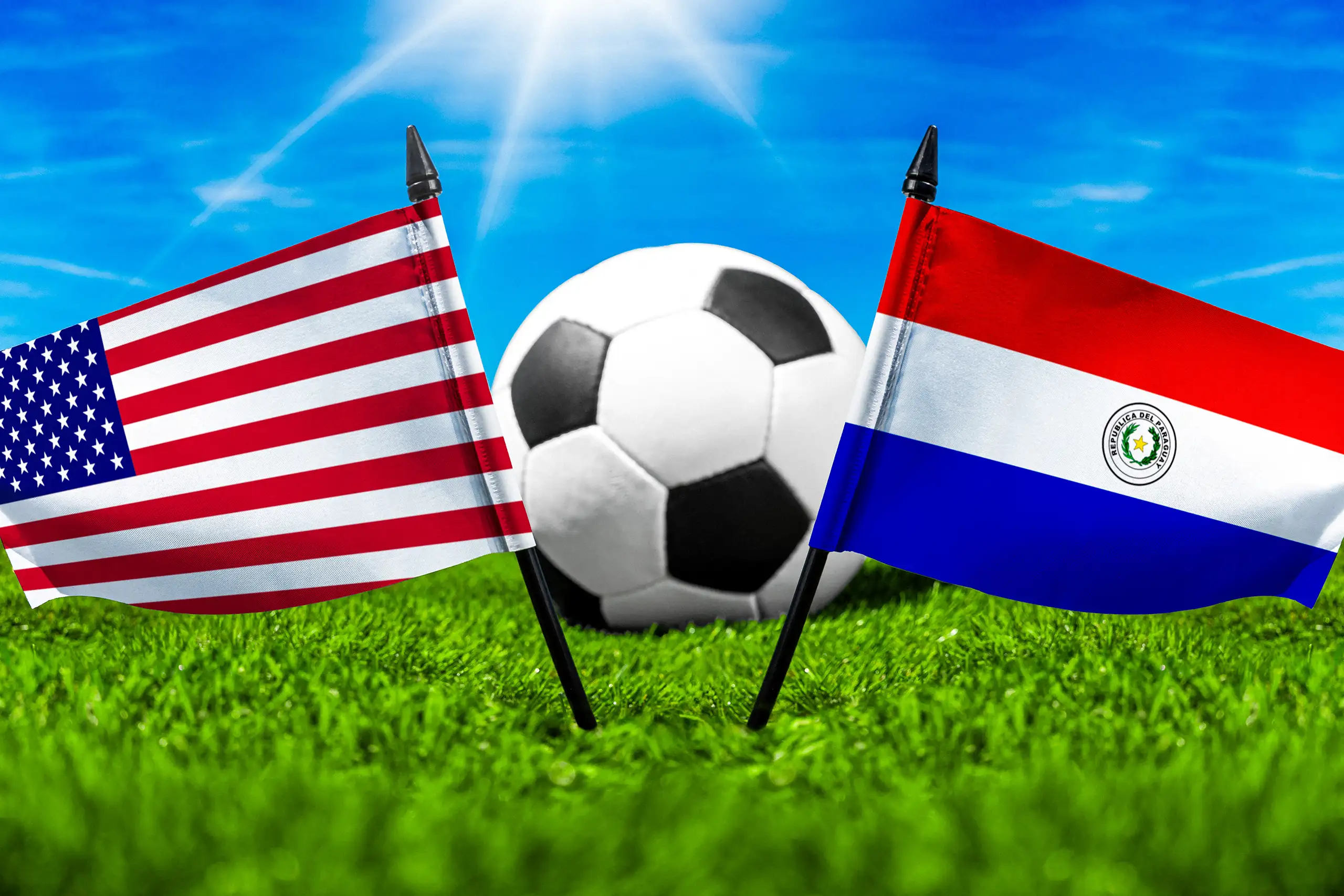 usa paraguay fußballspiel mit fußball zwischen den nationalflaggen der vereinigten staaten und paraguays auf grünem spielfeldrasen.