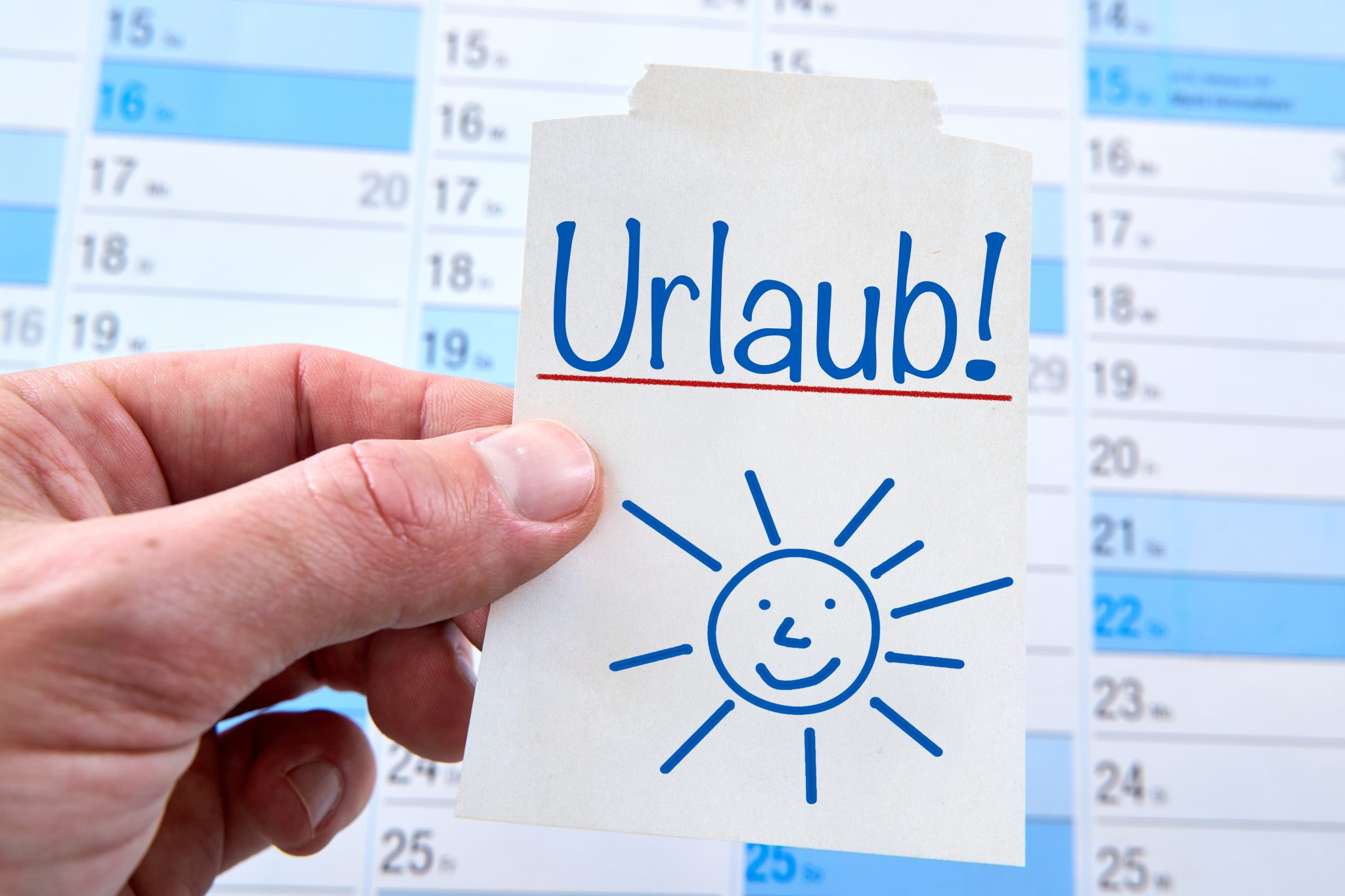 URLAUB SCHRIFTZUG URLAUB AUF EINER NOTIZ VOR EINEM KALENDER schriftzug urlaub auf einer notiz vor einem kalender