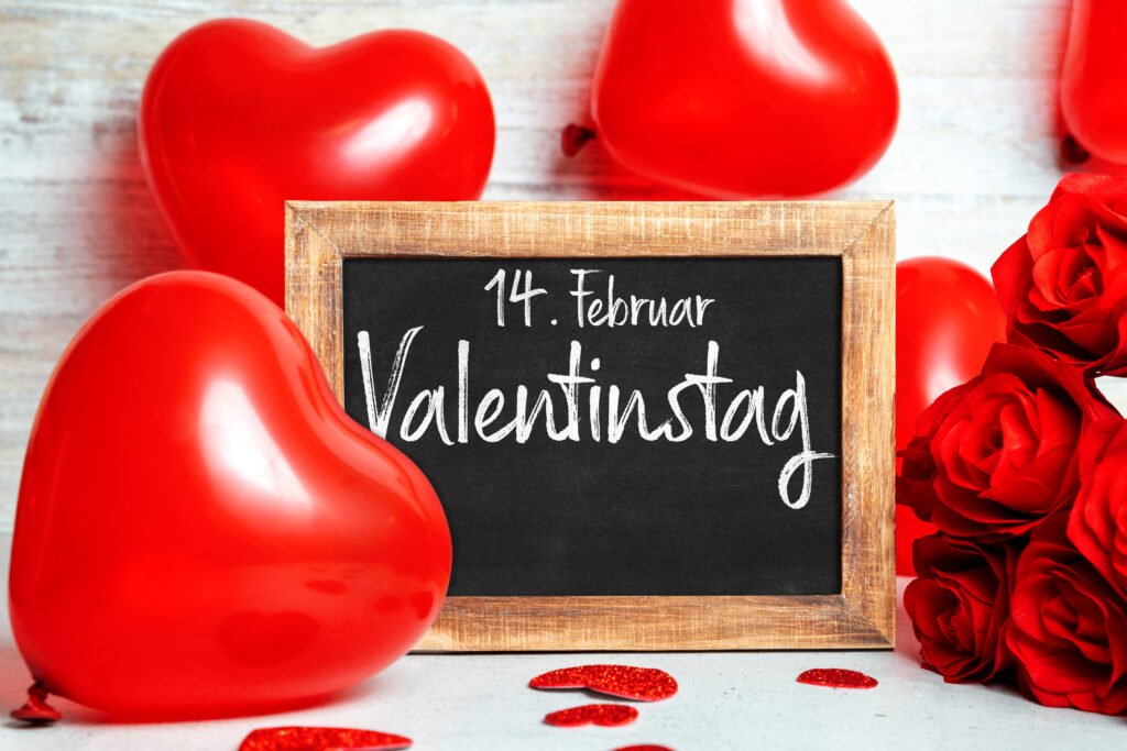 Valentinstag am 14. Februar mit roten Herzen, roten Rosen und Tafel