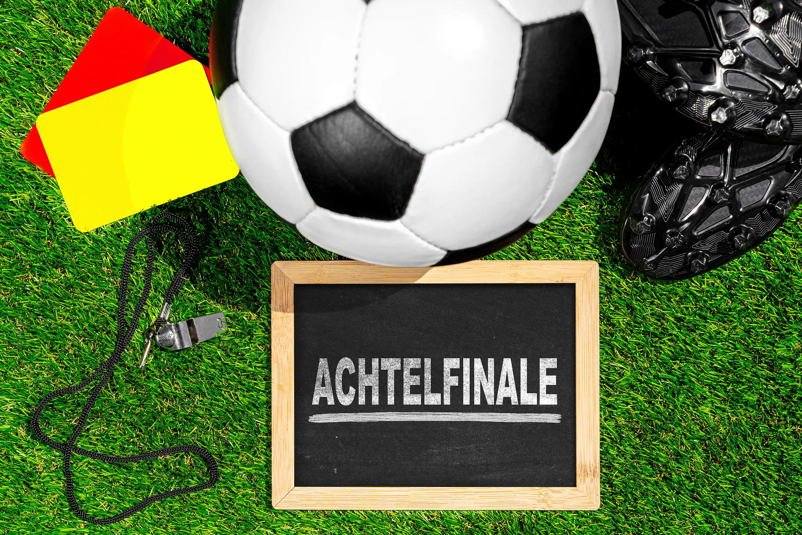 achtelfinale-tafel mit fußball, schiedsrichterpfeife, karten und fußballschuhen auf grünem rasen.