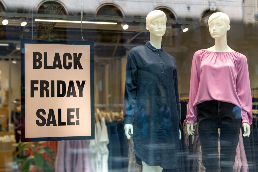 Black Friday Sale Schaufenster – Werbeschild mit Aufschrift BLACK FRIDAY SALE vor Modepuppen im Geschäft