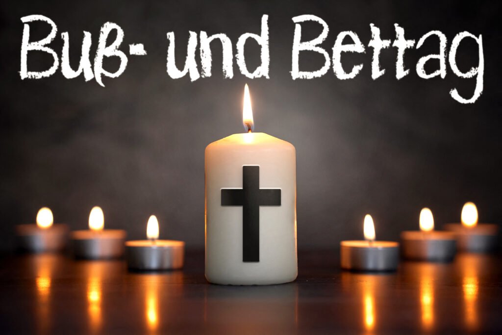 Symbolisches Bild zum Buß- und Bettag mit brennender Kerze und Kreuz