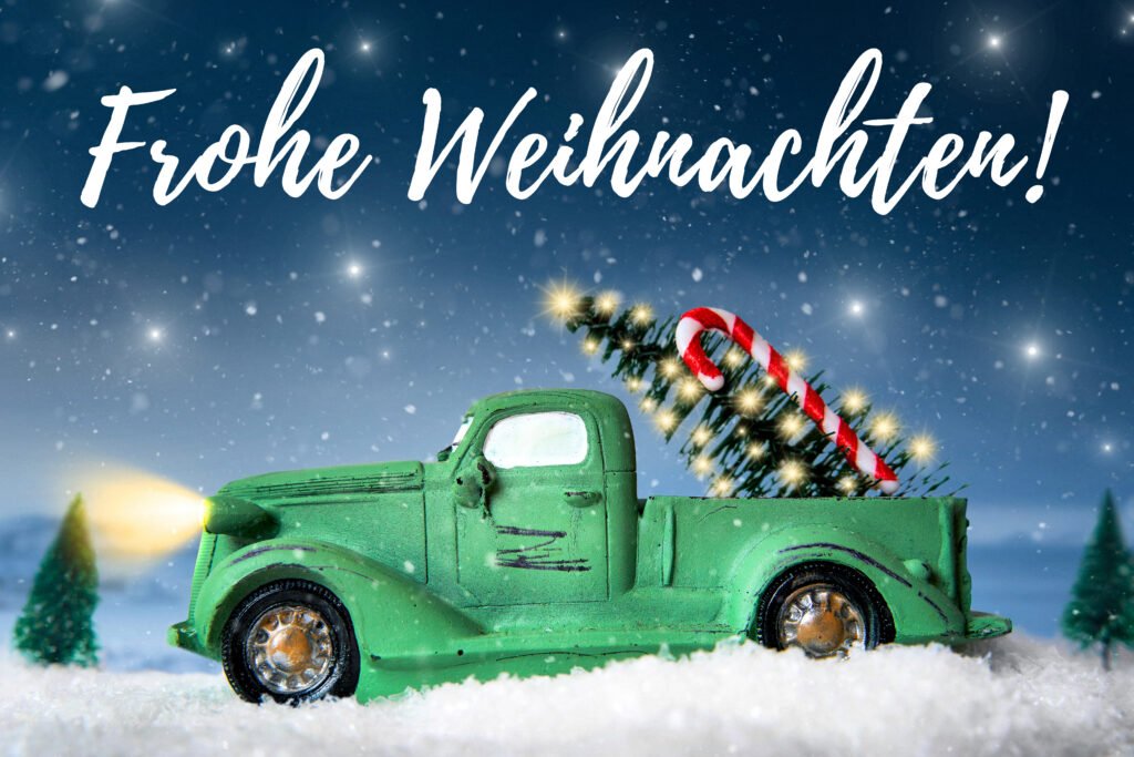 Frohe Weihnachten – winterliches Weihnachtsbild mit grünem Auto, Tannenbaum und Schnee