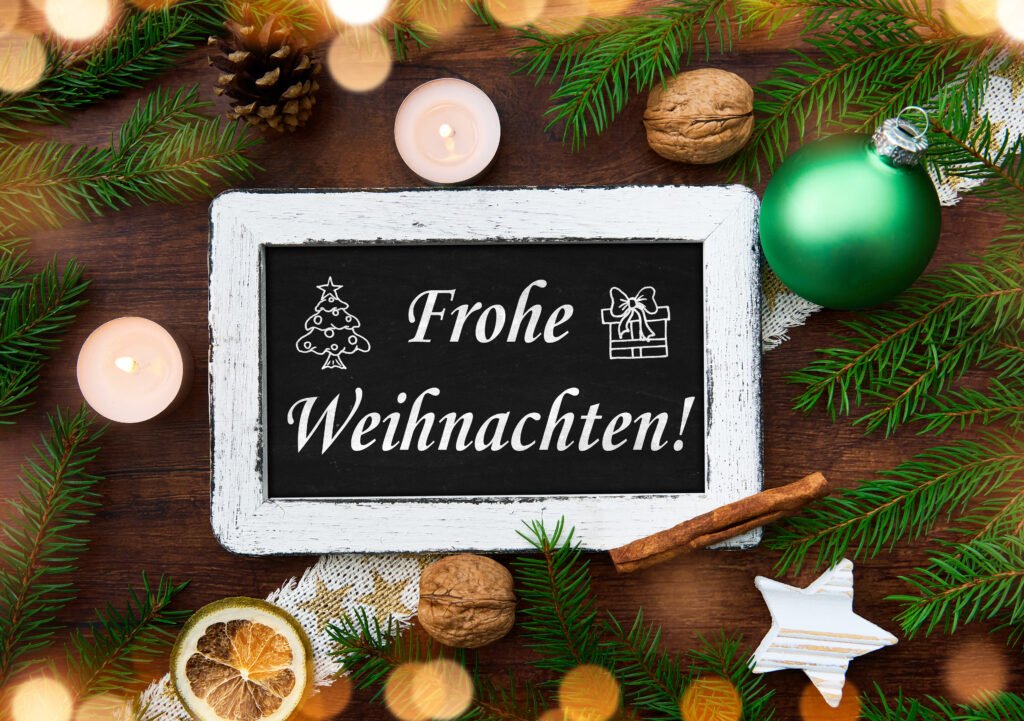 Frohe Weihnachten – festliches Weihnachtsbild mit Kerzen, Tannenzweigen und Dekoration