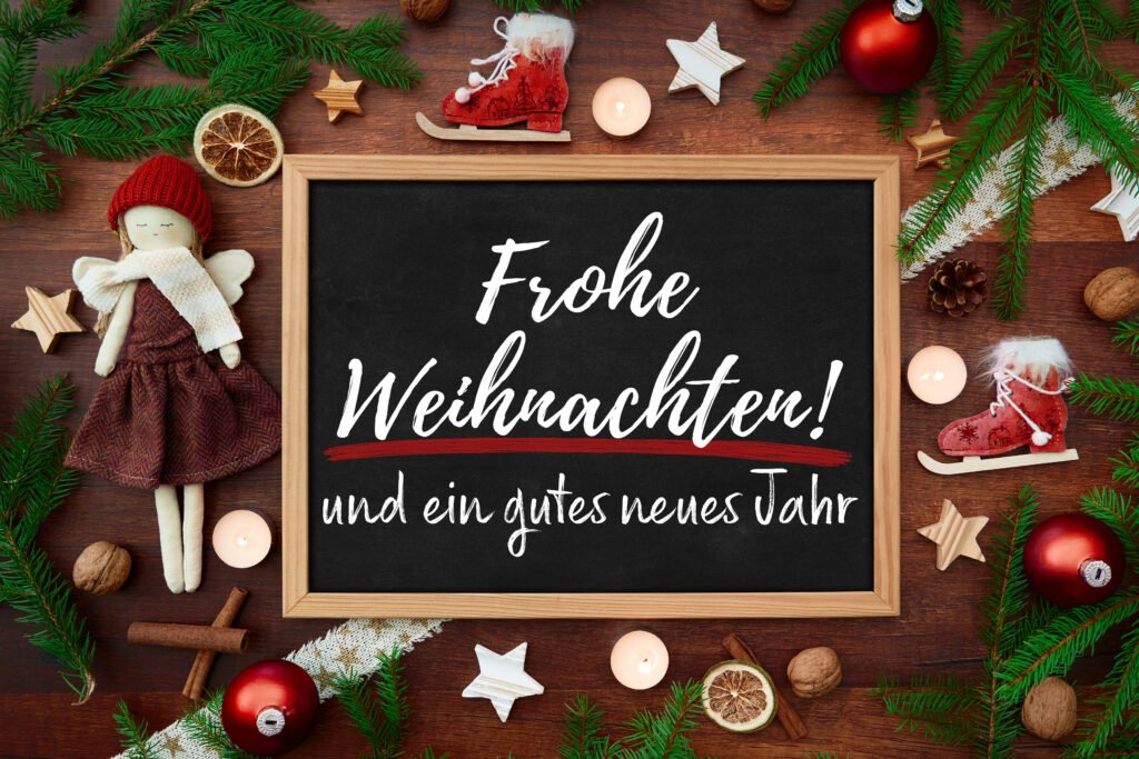 Frohe Weihnachten und ein gutes neues Jahr – festliche Weihnachtsdeko mit Engel, Tannenzweigen und Kerzen