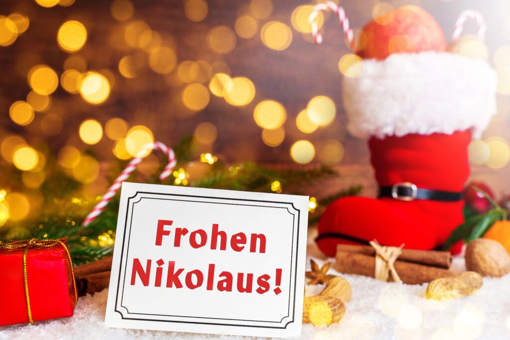 Frohen Nikolaus – festlicher Nikolausgruß mit rotem Stiefel, Nüssen, Mandarinen und leuchtendem Hintergrund