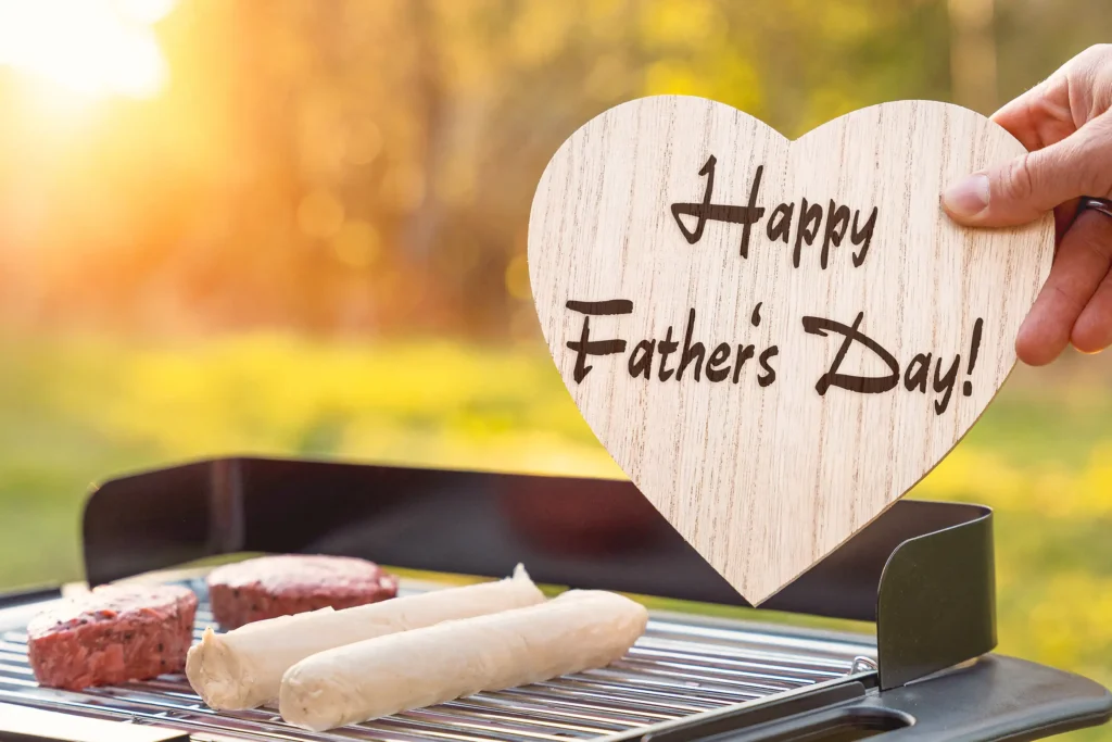 Happy Father's Day image with wooden heart sign above a barbecue grill