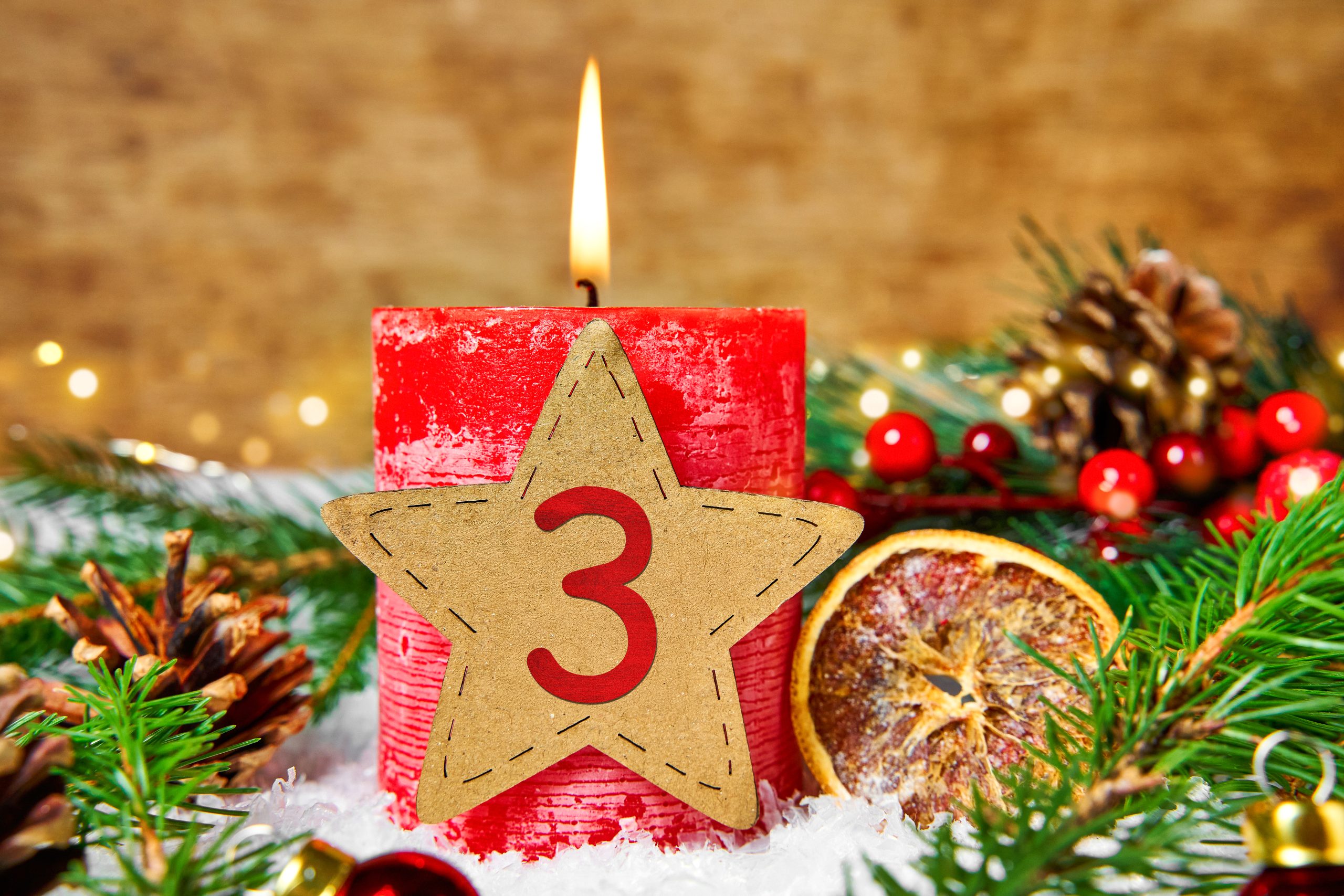 dritter 3. advent, dritte adventskerze brennt vor winterlicher dekoration