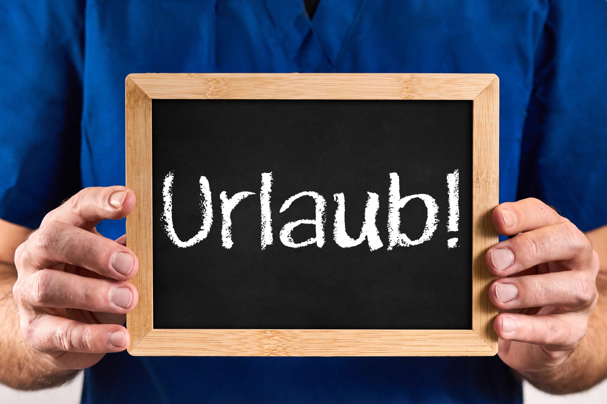 URLAUB ARZT HÄLT EIN SCHILD MIT DER AUFSCHRIFT URLAUB arzt hält ein schild mit der aufschrift urlaub