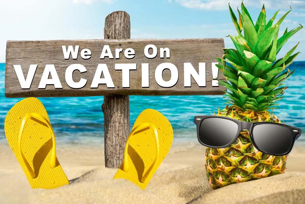 We Are On Vacation sign on a tropical beach with pineapple wearing sunglasses and yellow flip-flops in the sand.