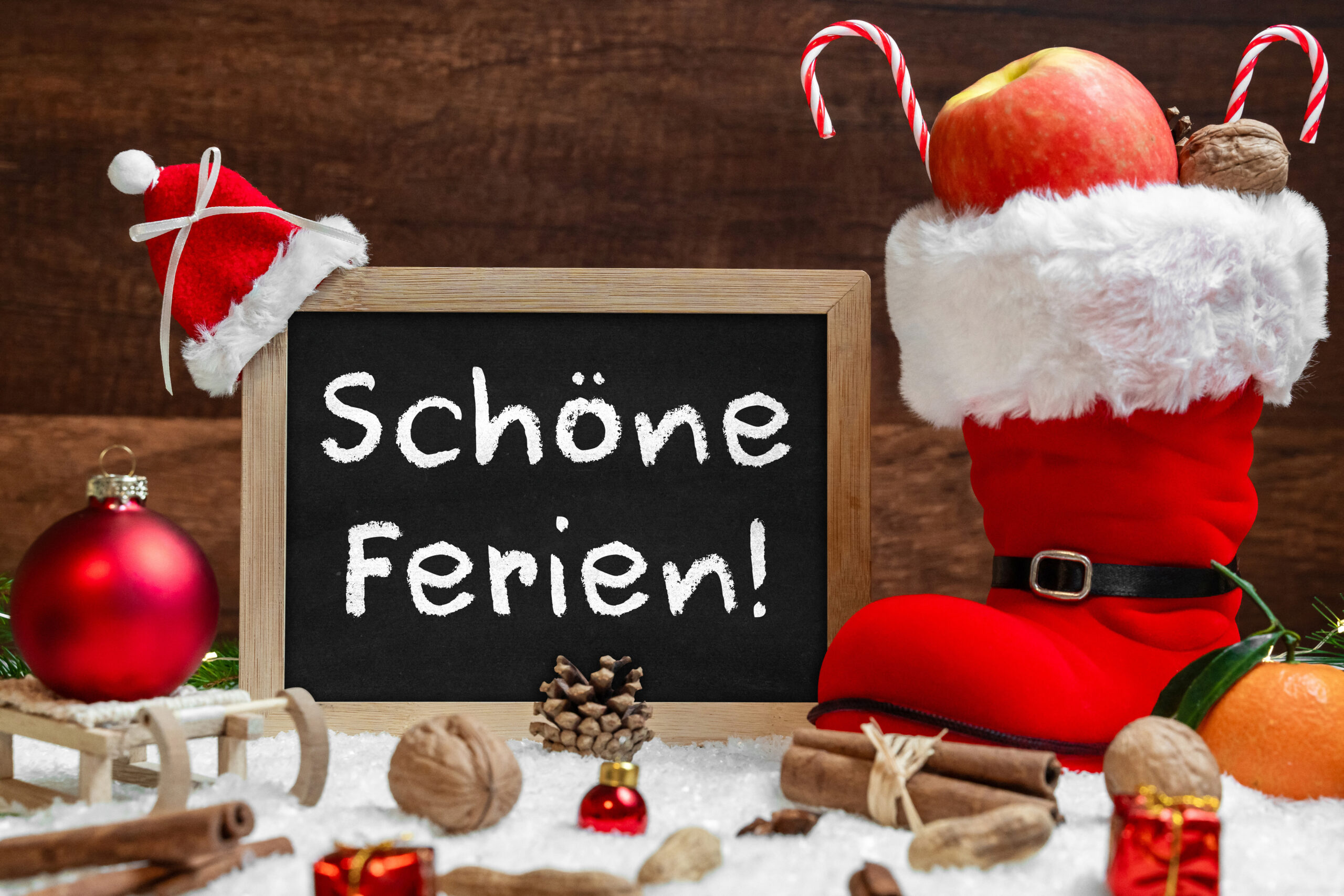 FERIEN BILDER WEIHNACHTSFERIEN – TAFEL MIT SCHRIFTZUG „SCHÖNE FERIEN!“ NEBEN NIKOLAUSSTIEFEL, APFEL, NUSS UND WEIHNACHTLICHER DEKORATION. weihnachtsferien – tafel mit schriftzug „schöne ferien!“ neben nikolausstiefel, apfel, nuss und weihnachtlicher dekoration.